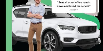 White man with brown hair standing with crossed arms in front of a white SUV car