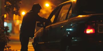 Most commonly stolen cars – A man breaking into a car at night